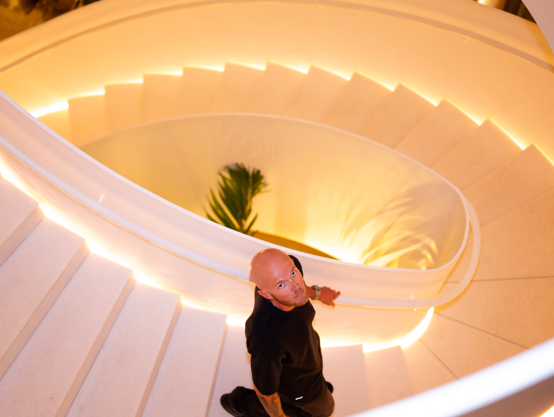 Overhead portrait of a man on a glowing spiral staircase
