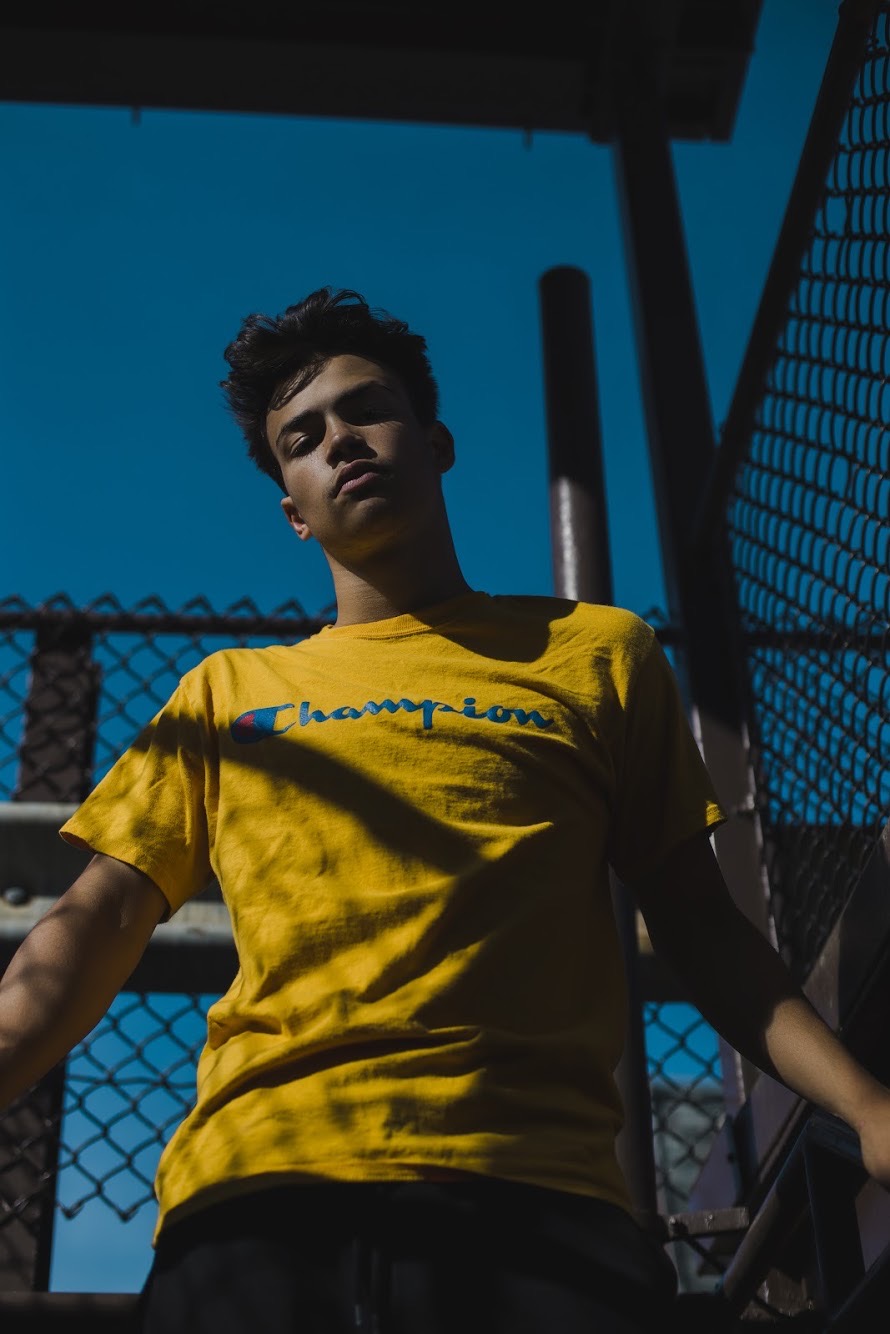 Low-angle fashion portrait beneath a vivid blue sky