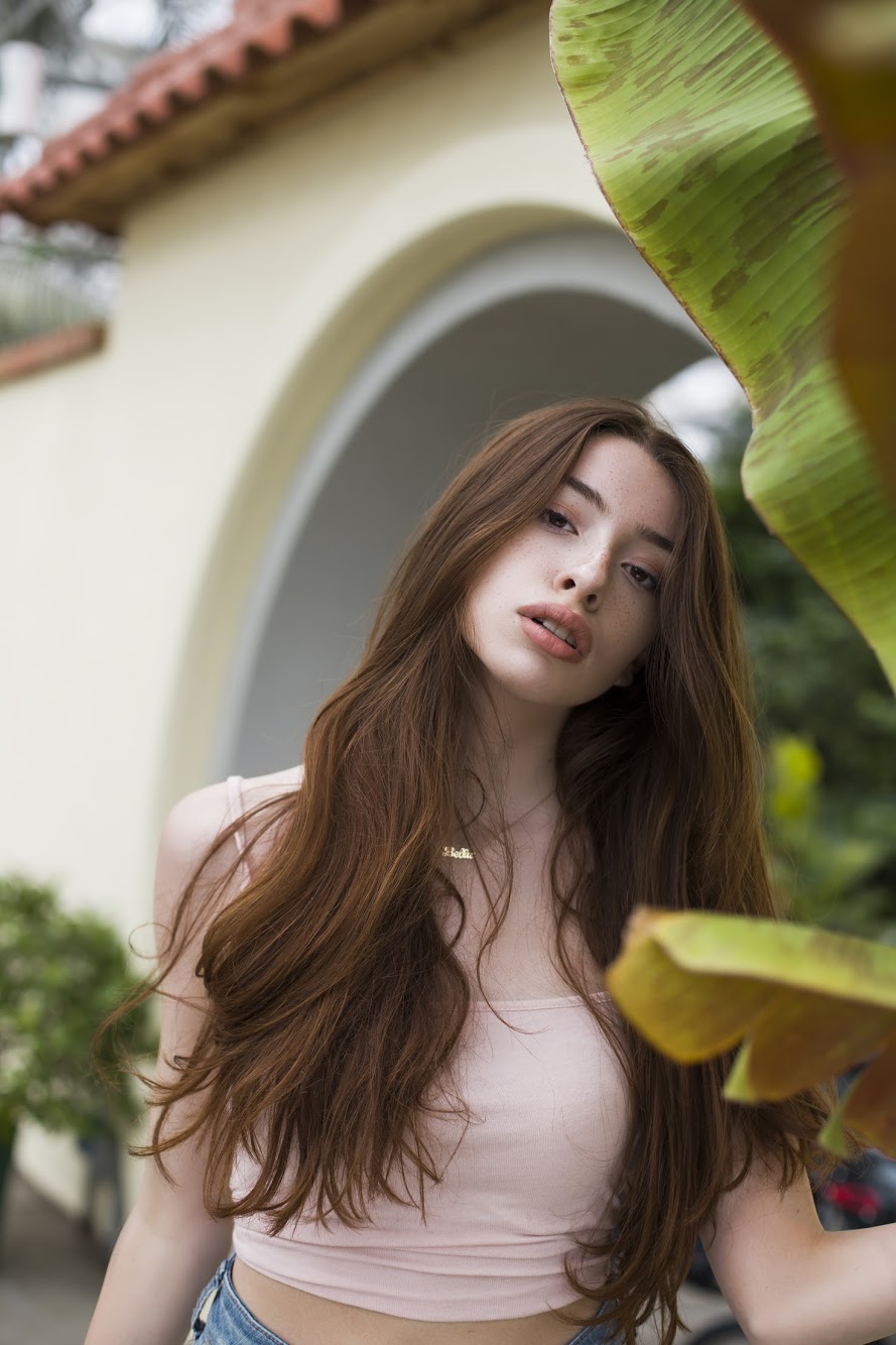 Portrait framed by tropical leaves and an archway